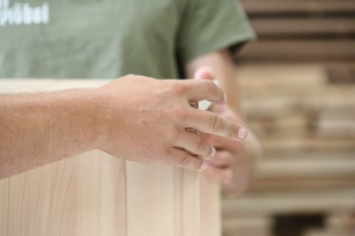Detailaufnahme von Händen bei der Bearbeitung von Massivholz