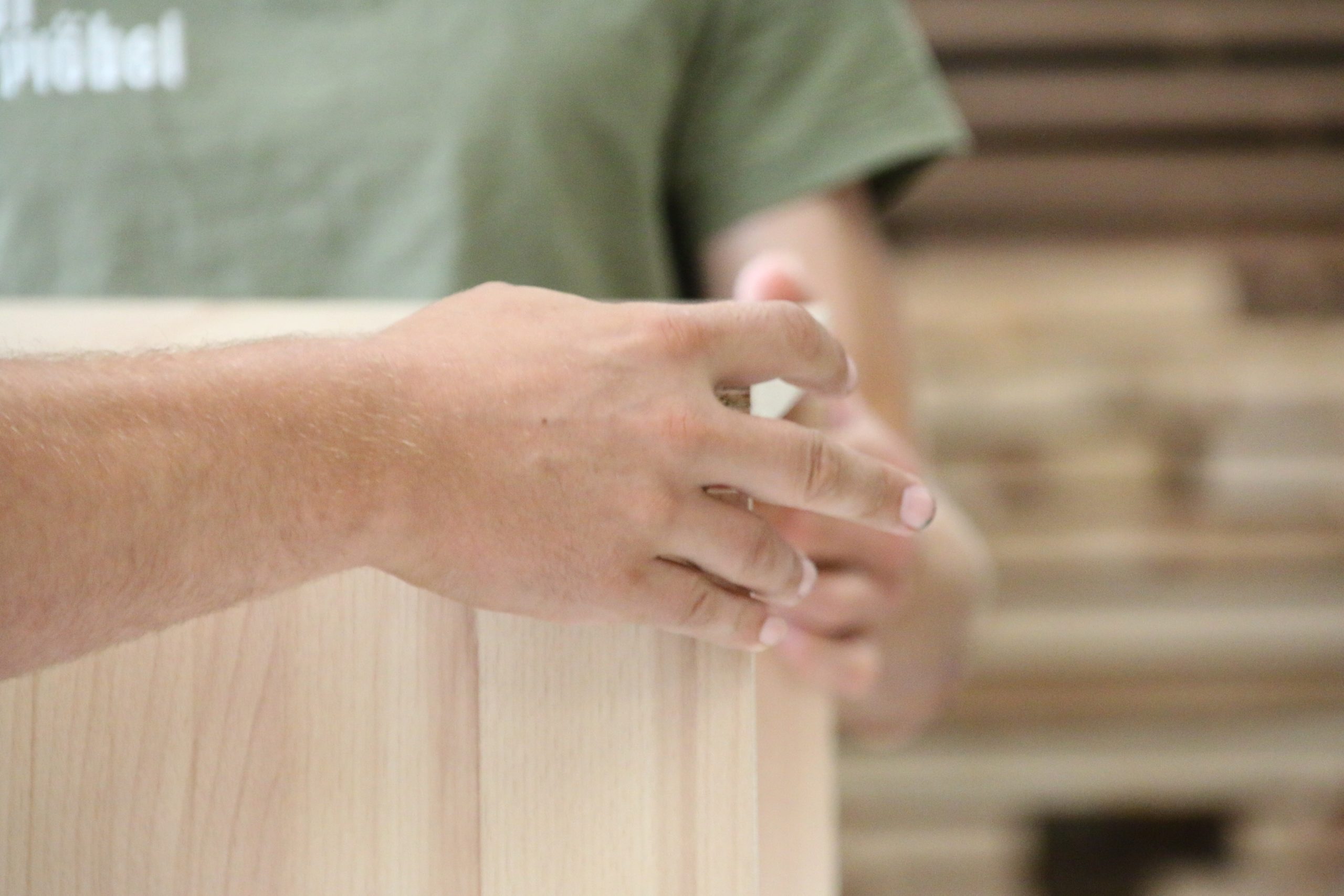 Detailaufnahme von Händen bei der Bearbeitung von Massivholz