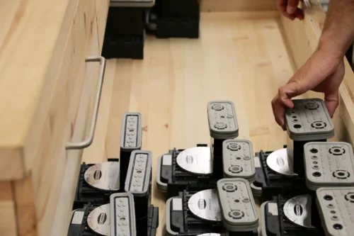 Nahaufnahme einer hölzernen Schublade in unserer Werkstatt, in der mehrere CNC-Vakuumsauger systematisch gelagert werden.