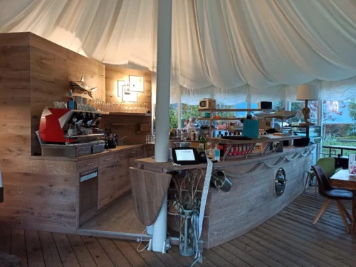 Modern gestalteter Schankbereich eines Cafe- und Barbetriebes mit Theke in Form eines Schiffsrumpfes
