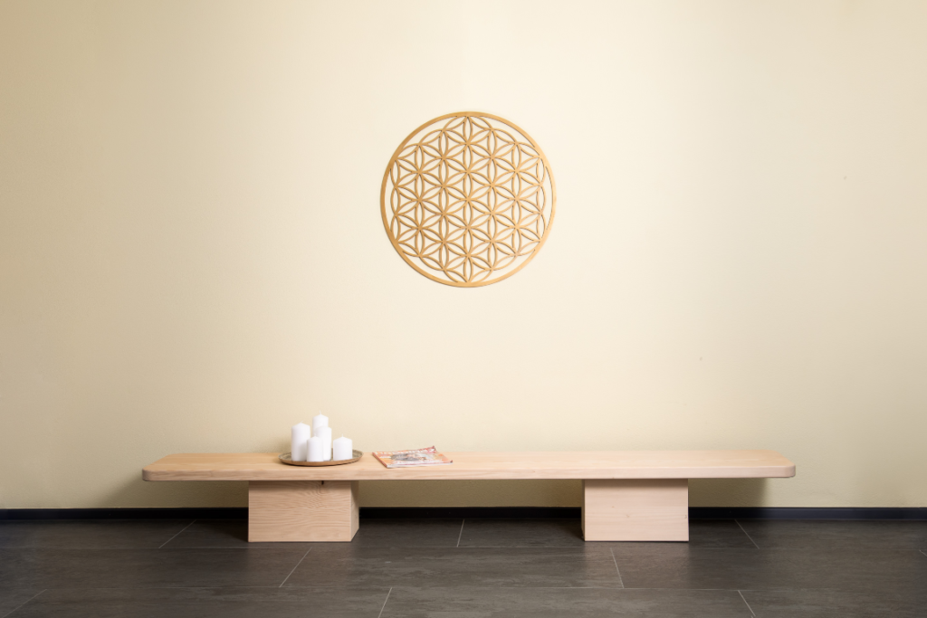 Yogastudio mit sehr niedrigem Sideboard aus Massivholz und gefräster Wanddekoration "Blume des Lebens"